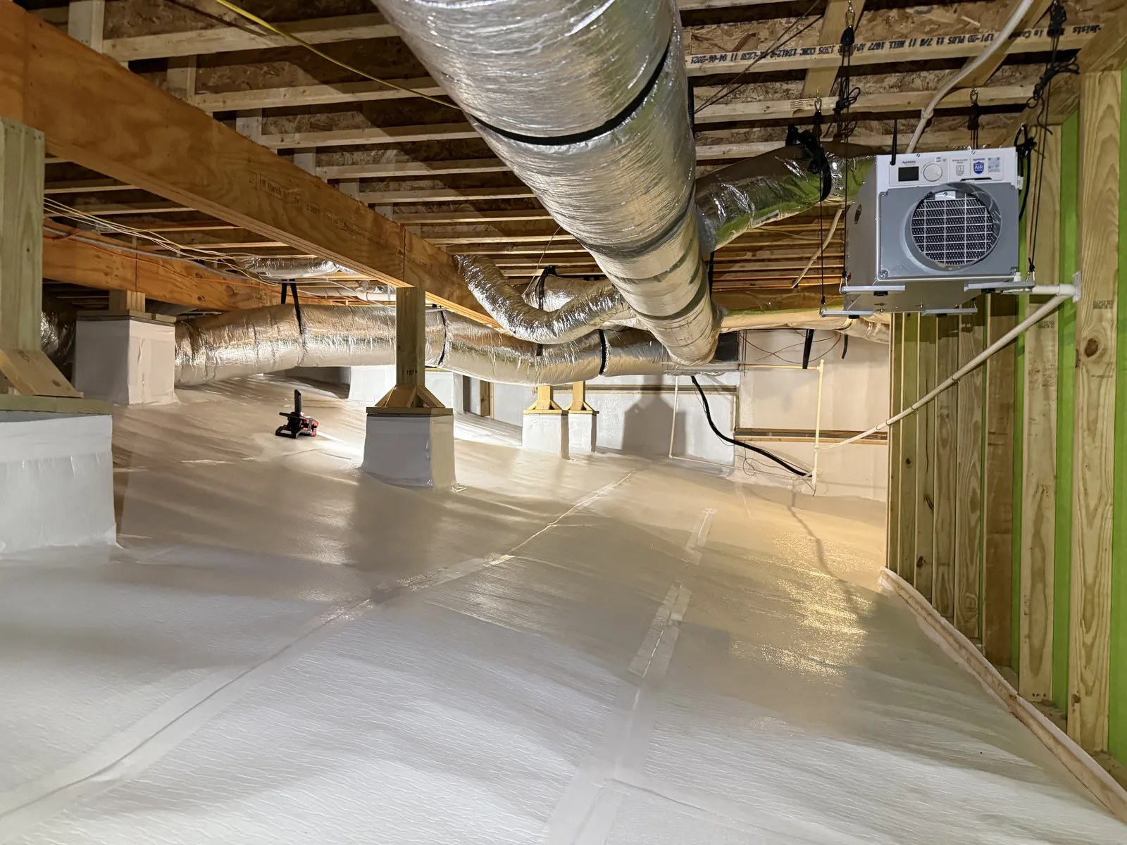 Encapsulated crawlspace with white vapor barrier floor, insulated flex ductwork and wall-mounted dehumidifier for moisture control, Chattanooga TN