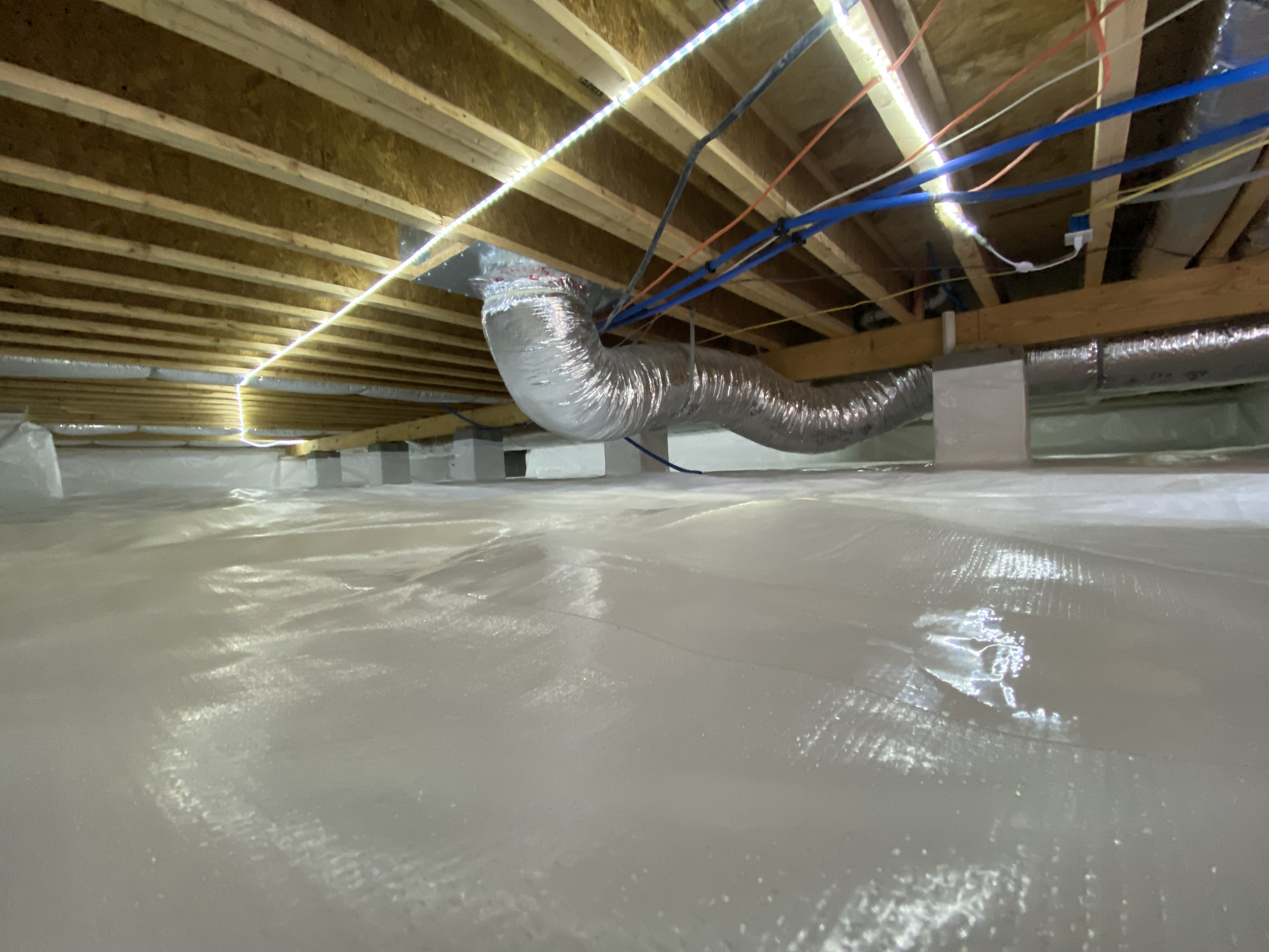 Fully encapsulated crawlspace with white liner covering floor and walls, multiple wrapped columns, Chattanooga TN