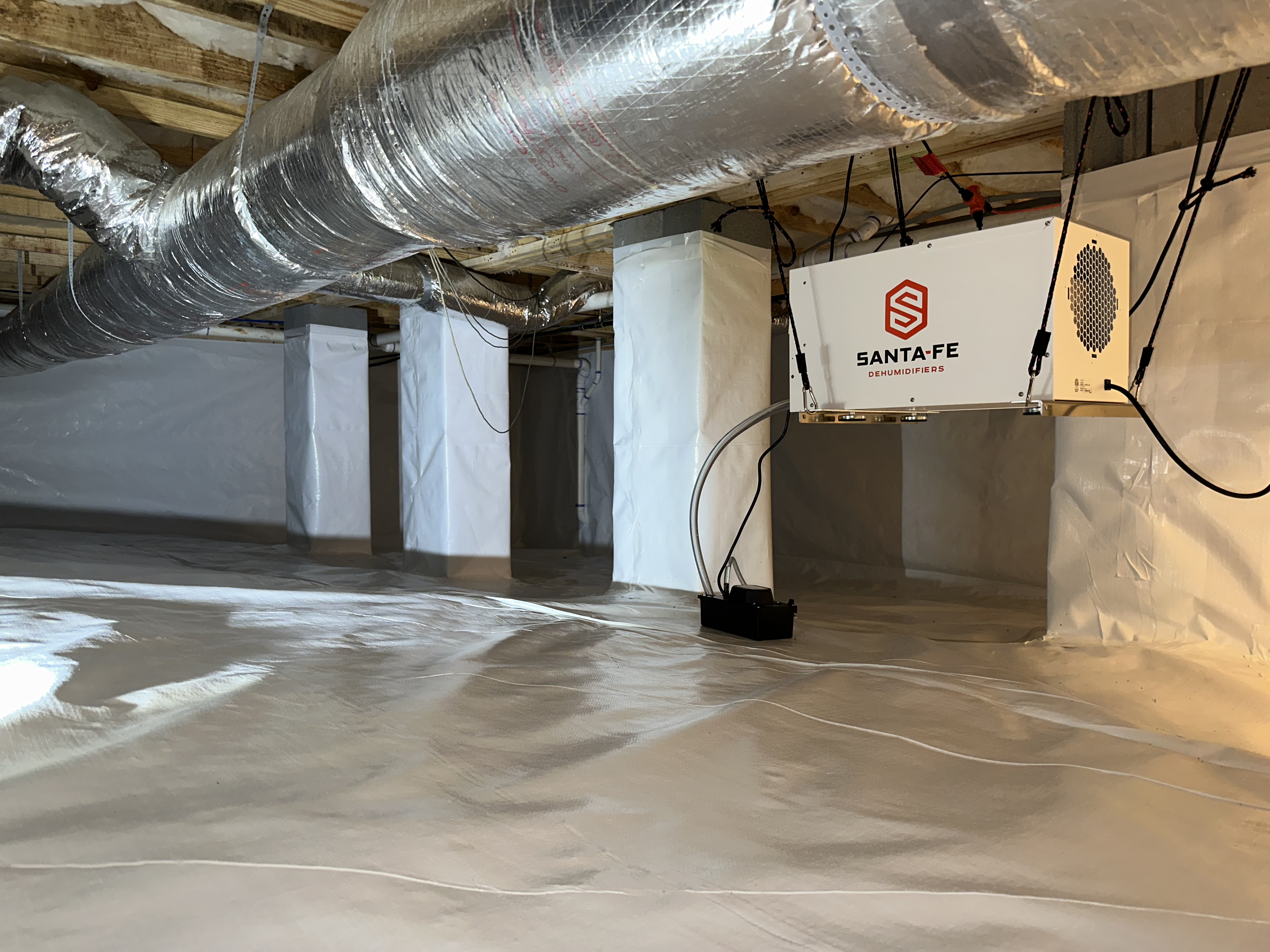 Large crawlspace encapsulation with clean white vapor barrier liner and HVAC ductwork, Hamilton County TN